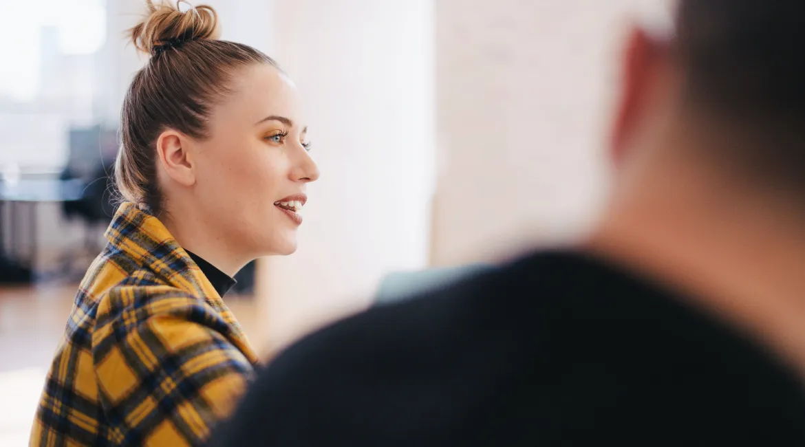 A woman and a men on a white room talking about giving the creative team feedback