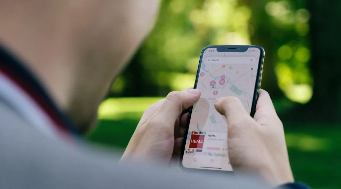 A man using the Google Maps, that includes Google Business Profiles, on his smartphone.