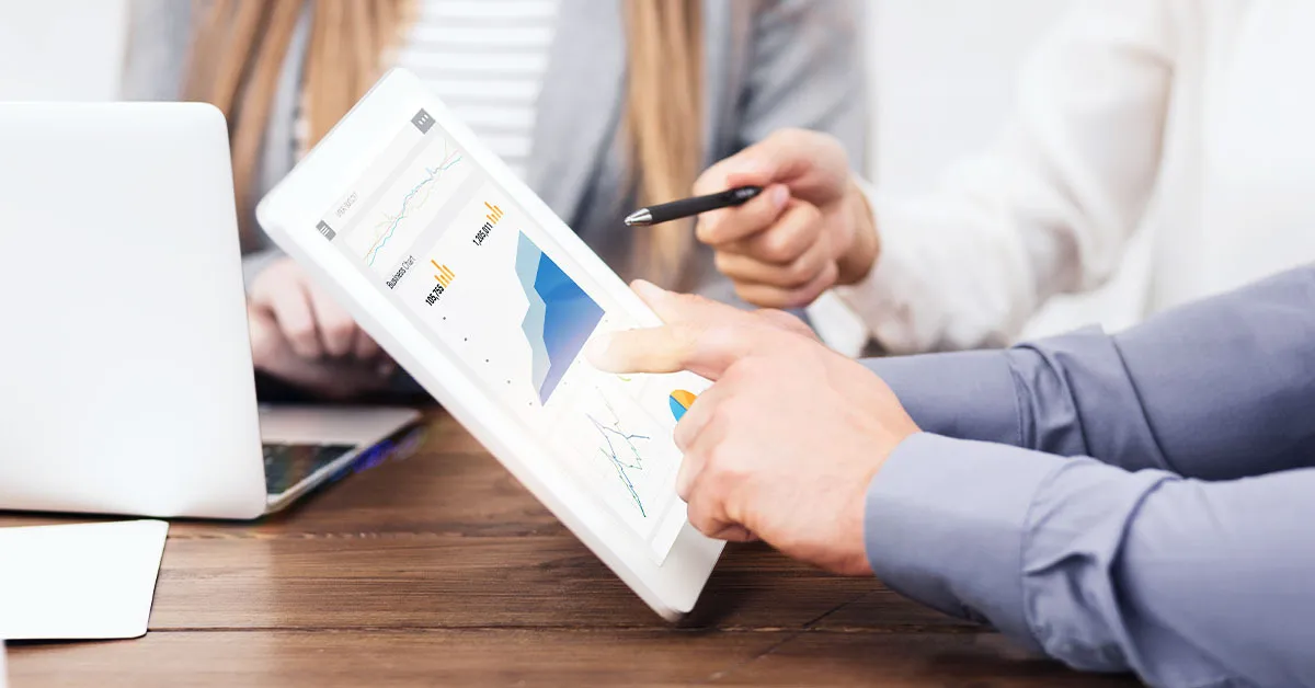 A man using a tablet to show his clients some results from effective backlinking strategies.