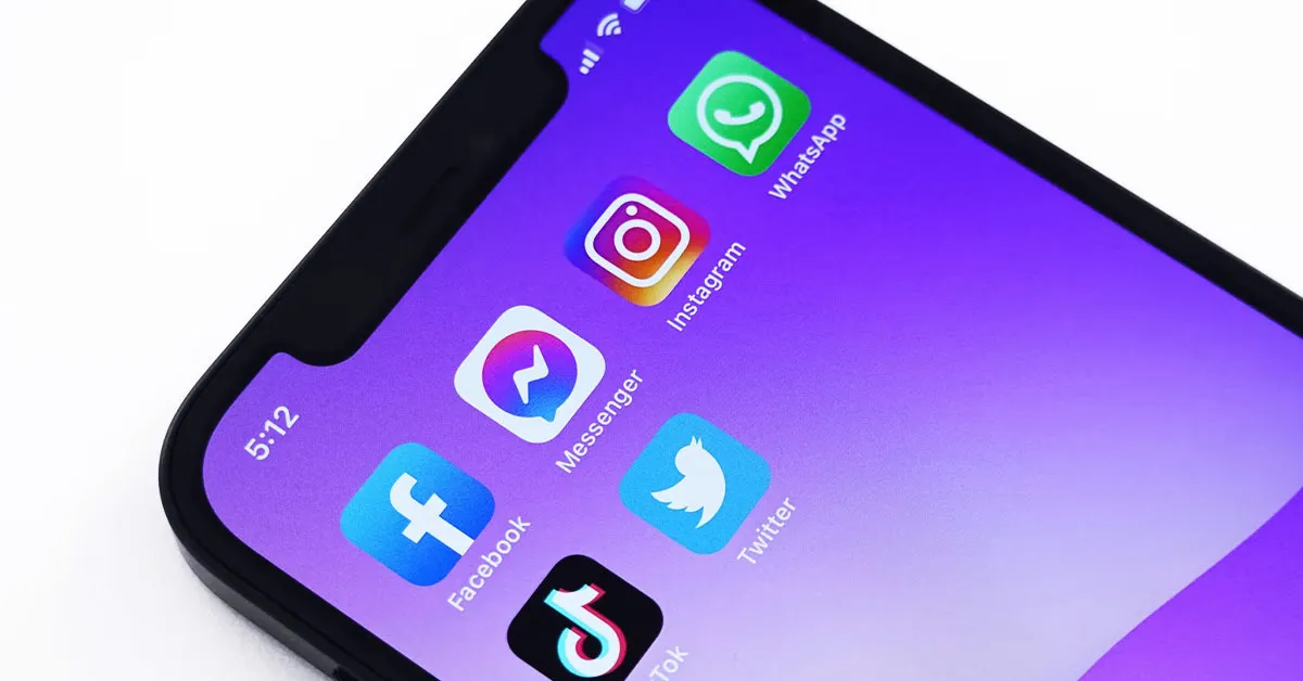 There's a smartphone with a screen on using presenting multiple social media platforms, such as Facebook, Messenger, Instagram, WhatsApp, Tik Tok and Twitter.