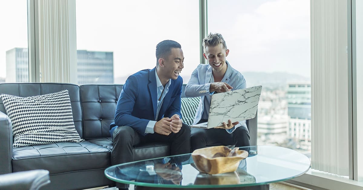 Two men looking at a laptop screen and learning about how to incorporate personalisation in digital marketing.