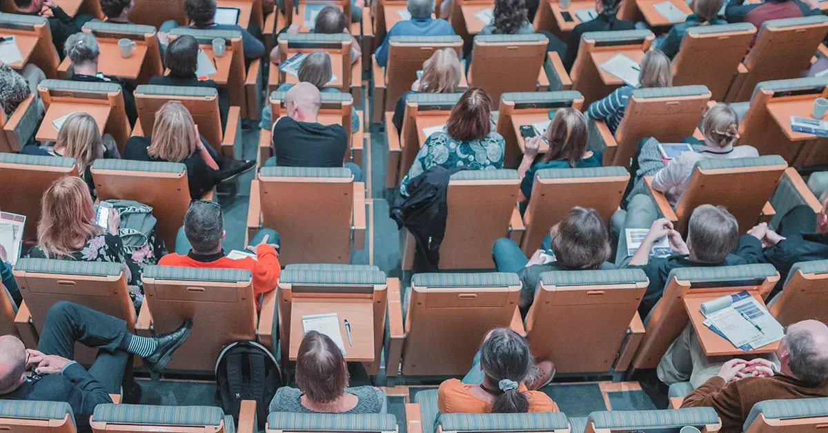There are many people seated on chairs representing the target audience.