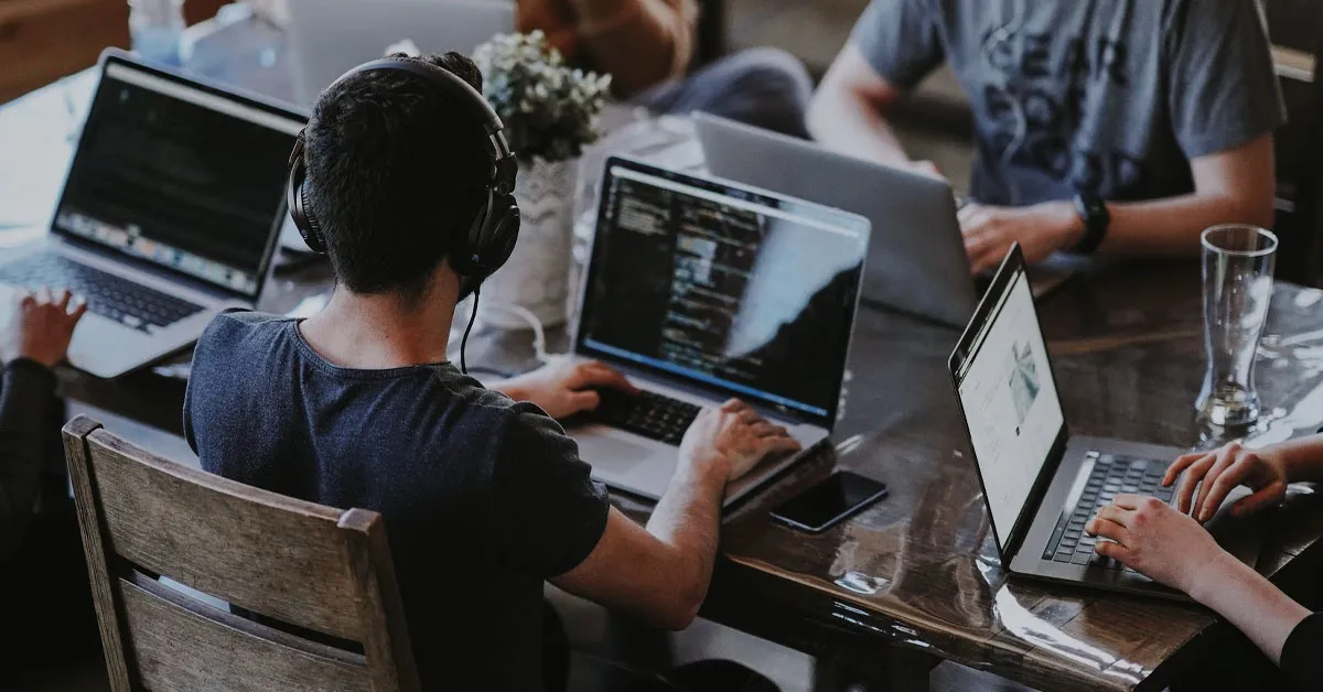 There are multiple people in the room while working on website development.