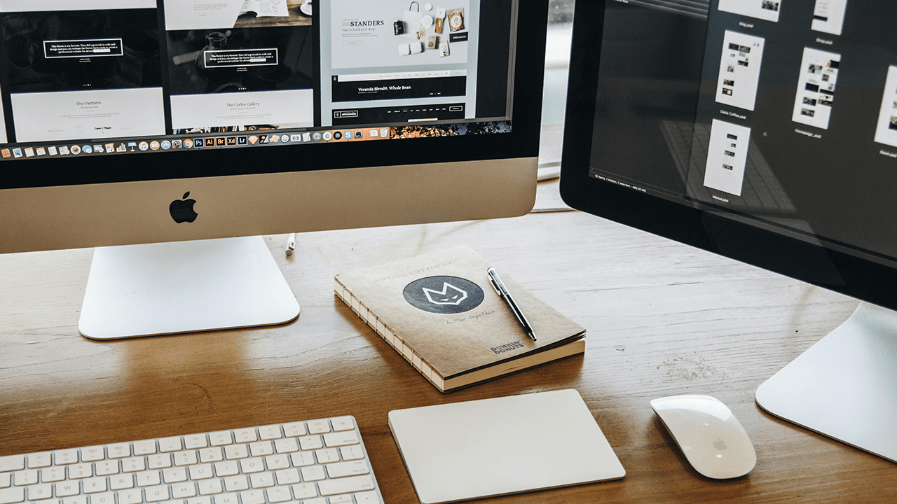 Two computer screens showing the website design process