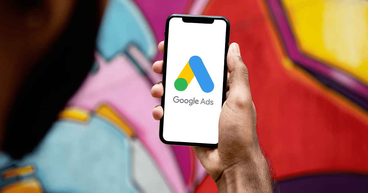 Person holding phone displaying Google Ads on the screen.