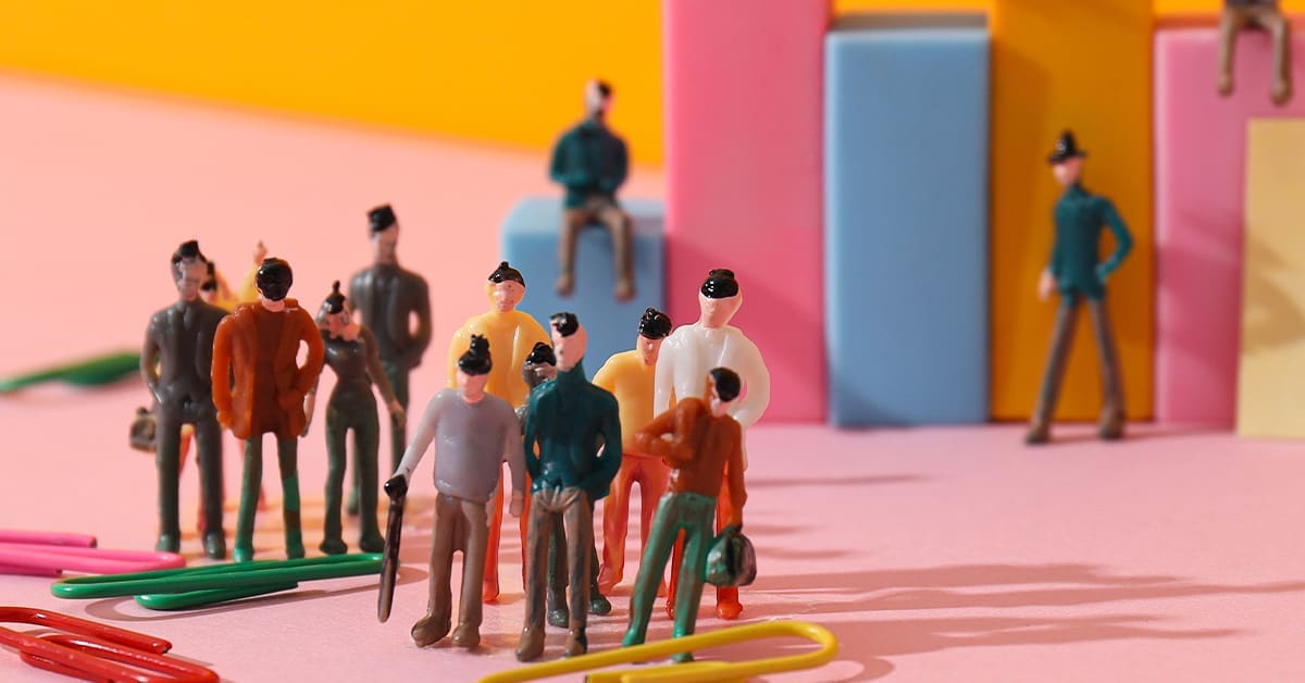Artistic figurines of people against a colourful background.